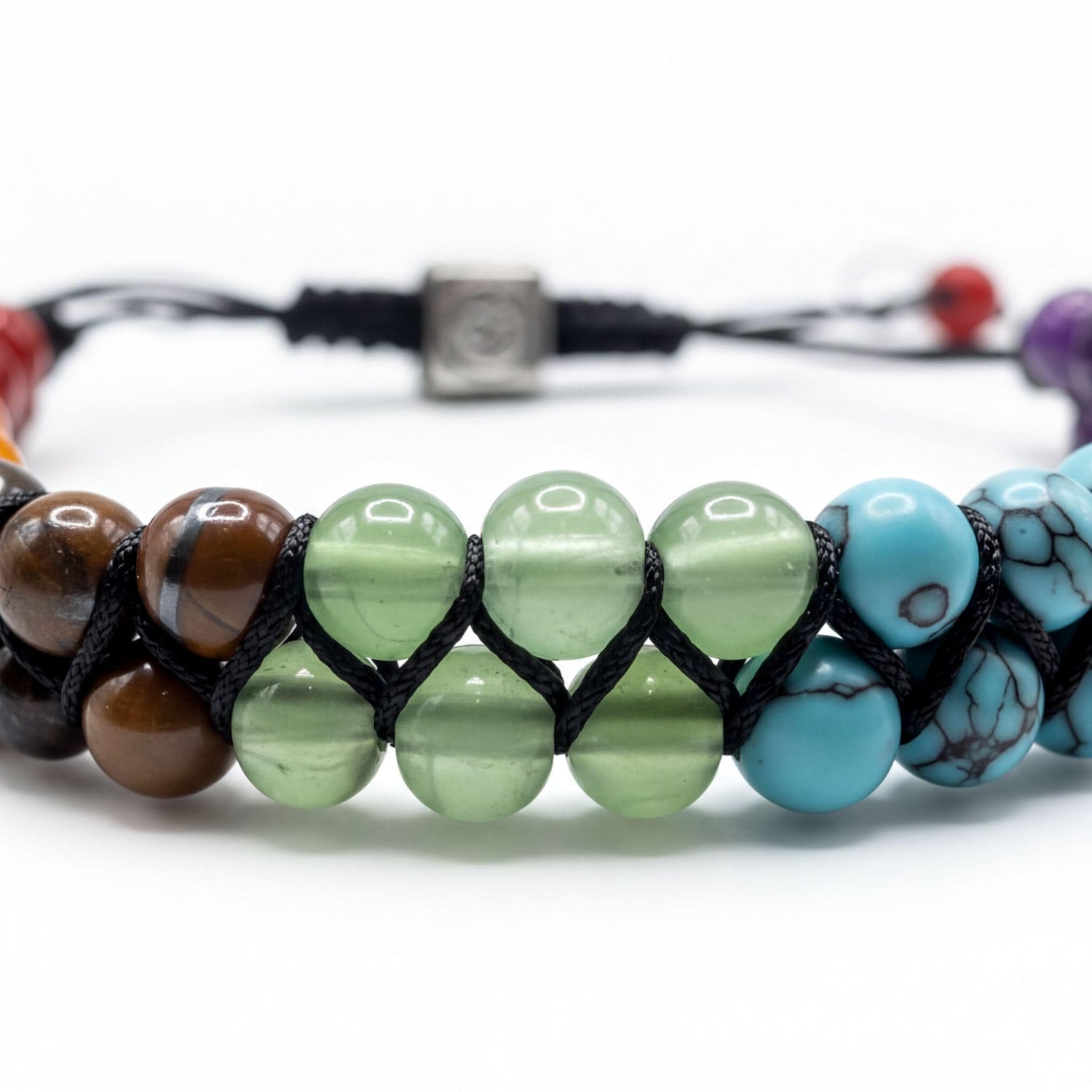 A colorful beaded bracelet with various colored beads, including green, blue, brown, and red, arranged in a row.