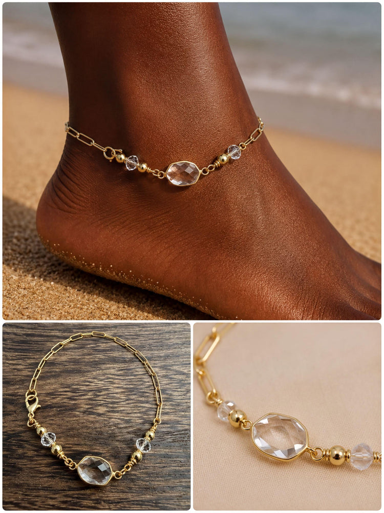 A gold-colored ankle bracelet with clear gemstones, worn on a person's ankle.