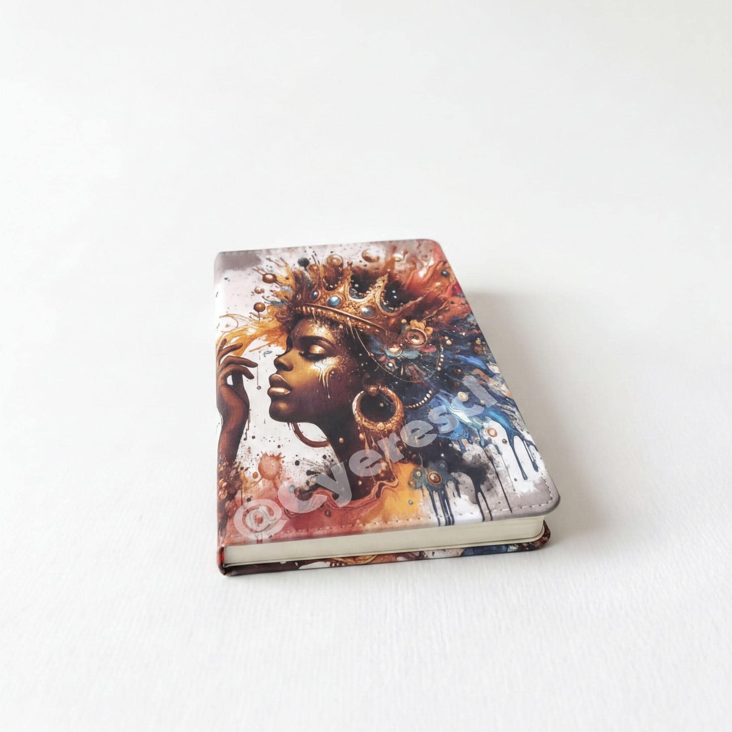 a notebook cover with an artistic portrait of a woman wearing a crown.