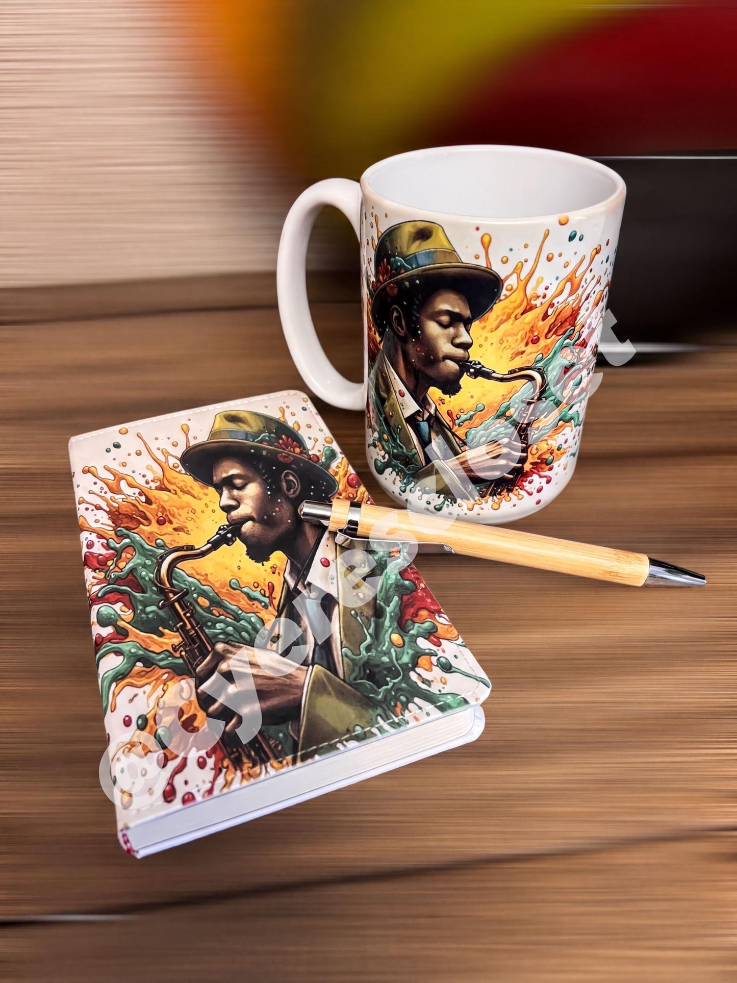 a white mug with a colorful design depicting a man playing a saxophone, and a small notebook with a similar design.