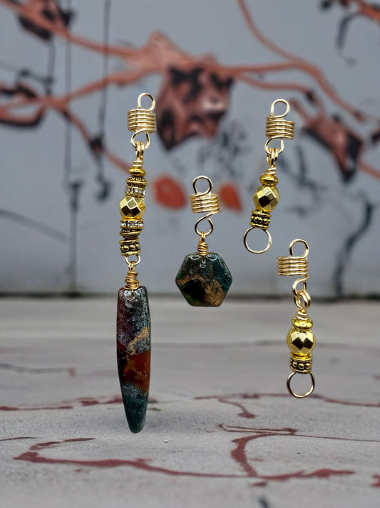 a collection of ornate, colorful earrings with various shapes and designs, including a large, multicolored stone and smaller, geometric shapes.