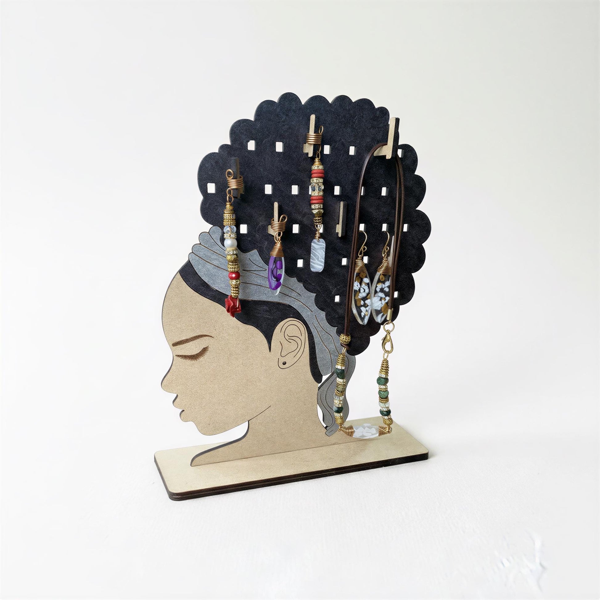 A wooden jewelry stand in the shape of a woman's head, displaying various earrings and necklaces.