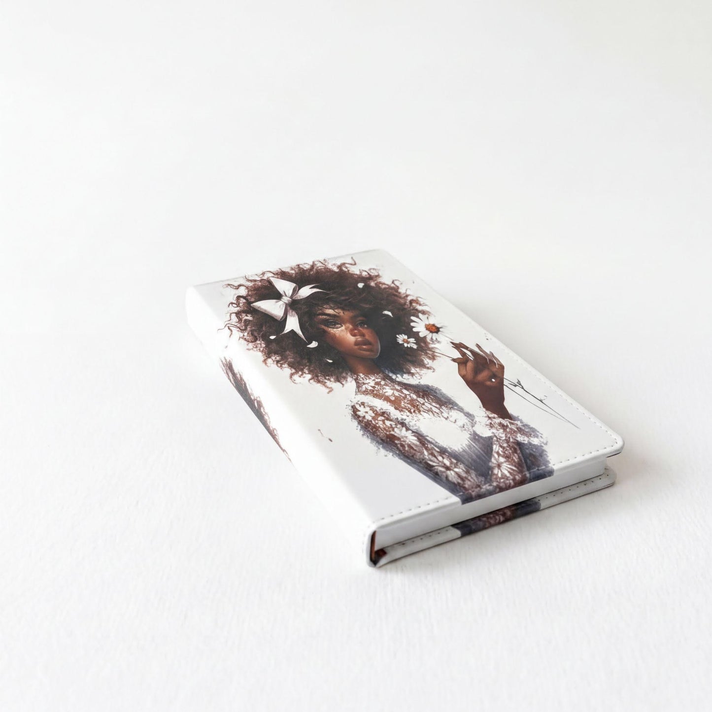 a white notebook with an artistic illustration of a woman's face on the cover.