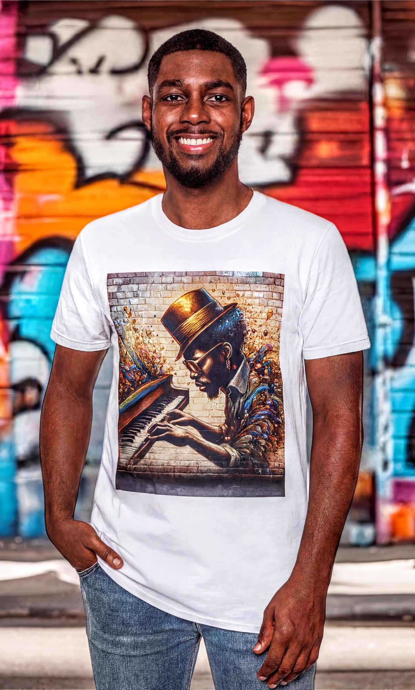 A smiling man wearing a white t-shirt with an artistic graphic of a person playing a musical instrument.