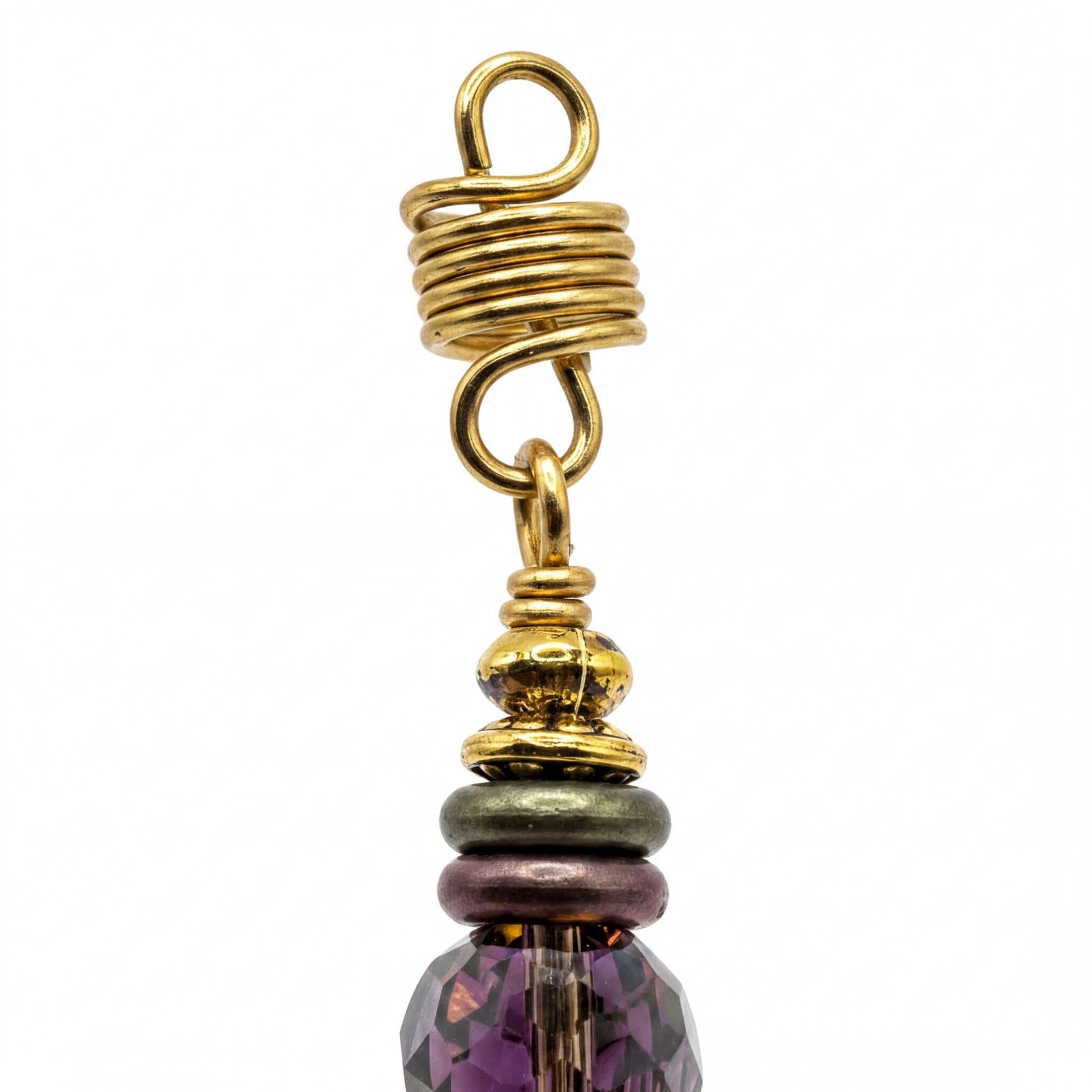 a close-up view of a decorative piece, possibly a necklace or earring, with a twisted metal component and a colorful bead at the top.