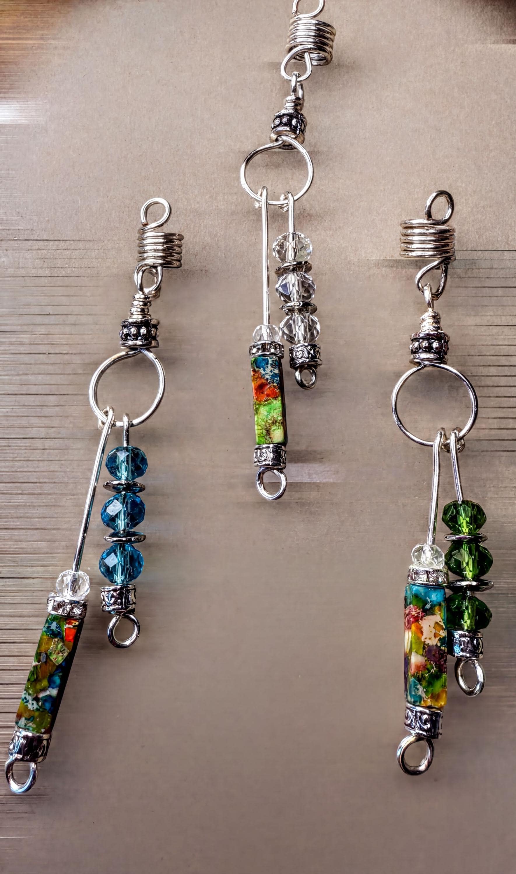 a collection of colorful, dangling earrings made of metal and glass beads.
