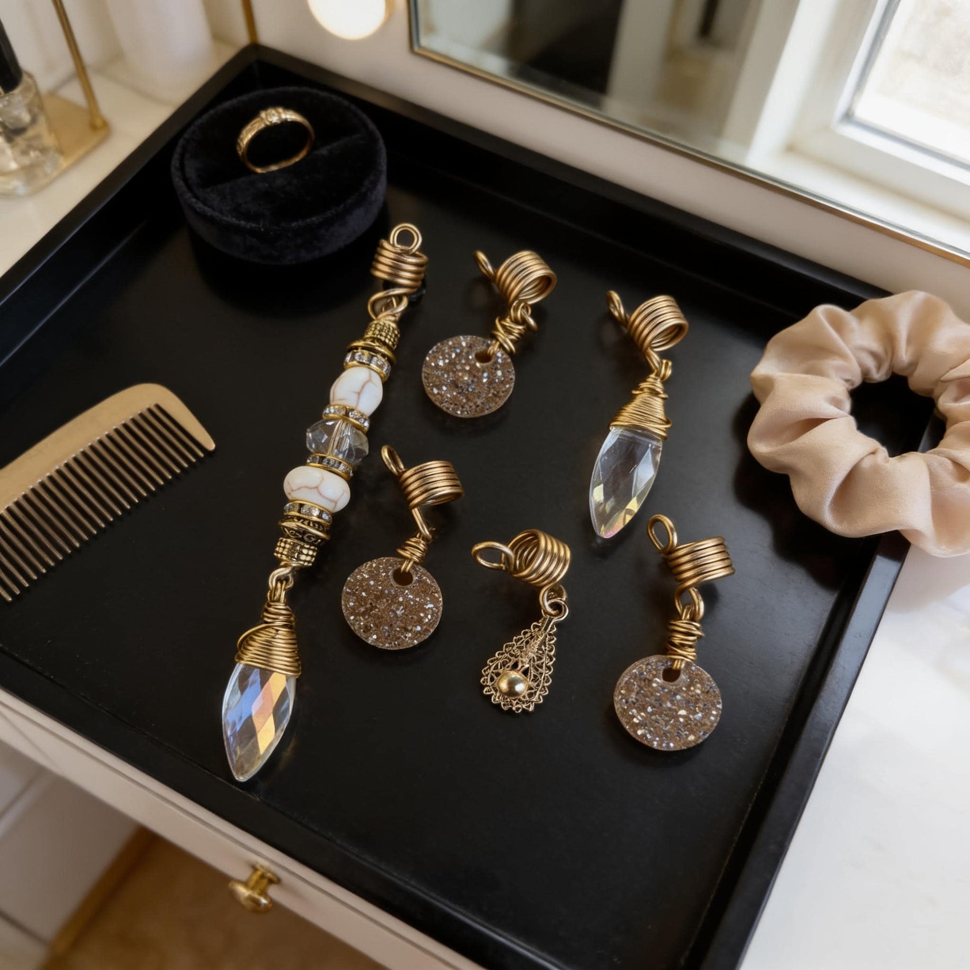 A collection of ornate jewelry and accessories, including a ring, earrings, and a hair tie, displayed on a black tray.