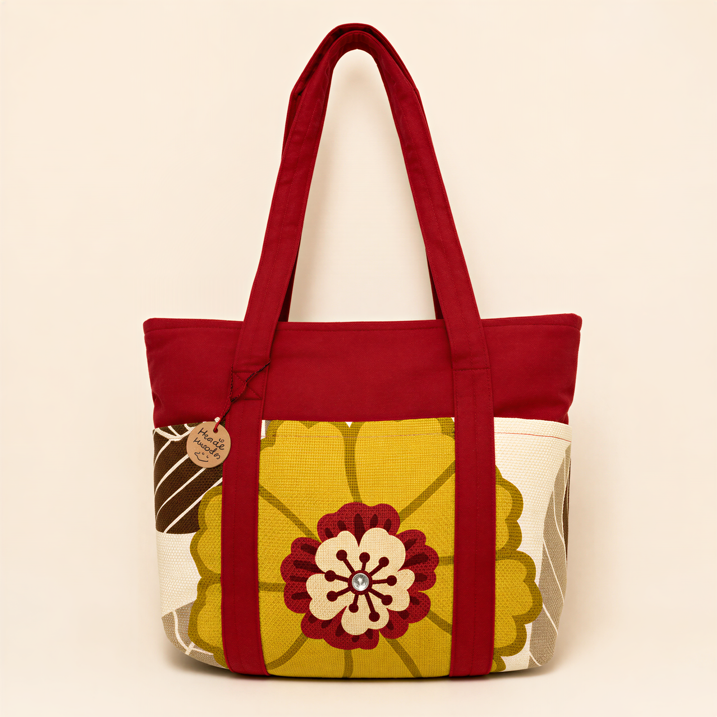 A red tote bag with a yellow and white floral pattern, featuring a large flower design in the center.