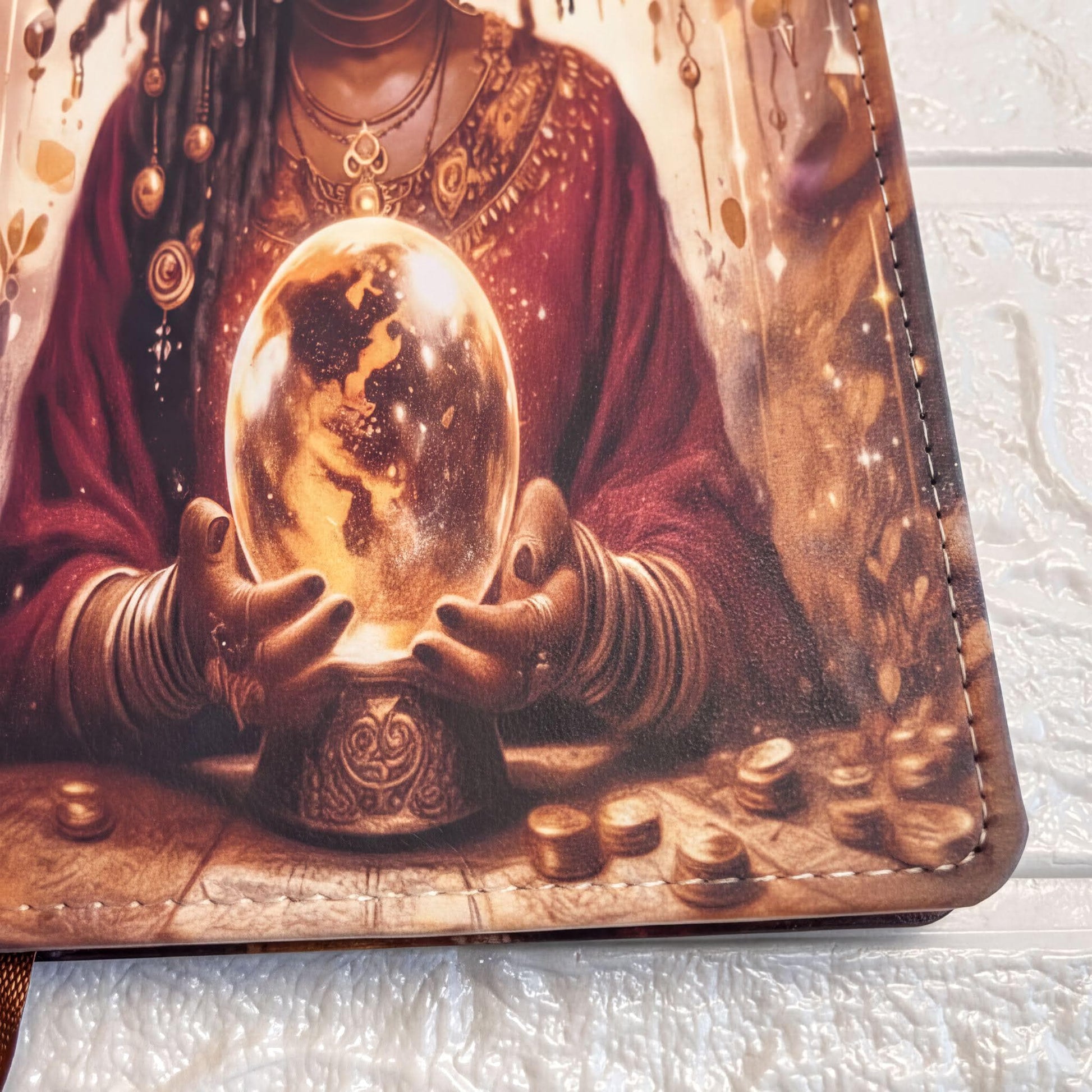 a woman holding a crystal ball, which appears to be a fortune teller's crystal ball. She is wearing a red robe and has a necklace around her neck. The crystal ball is placed on a table, surrounded by various objects, including coins.
