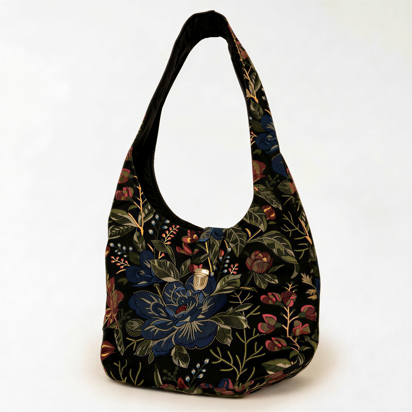 A black handbag with a floral pattern on the front, featuring a variety of colors including blue, green, red, and yellow.