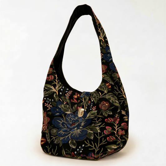 A black handbag with a floral pattern on the front, featuring a variety of colors including blue, green, red, and yellow.