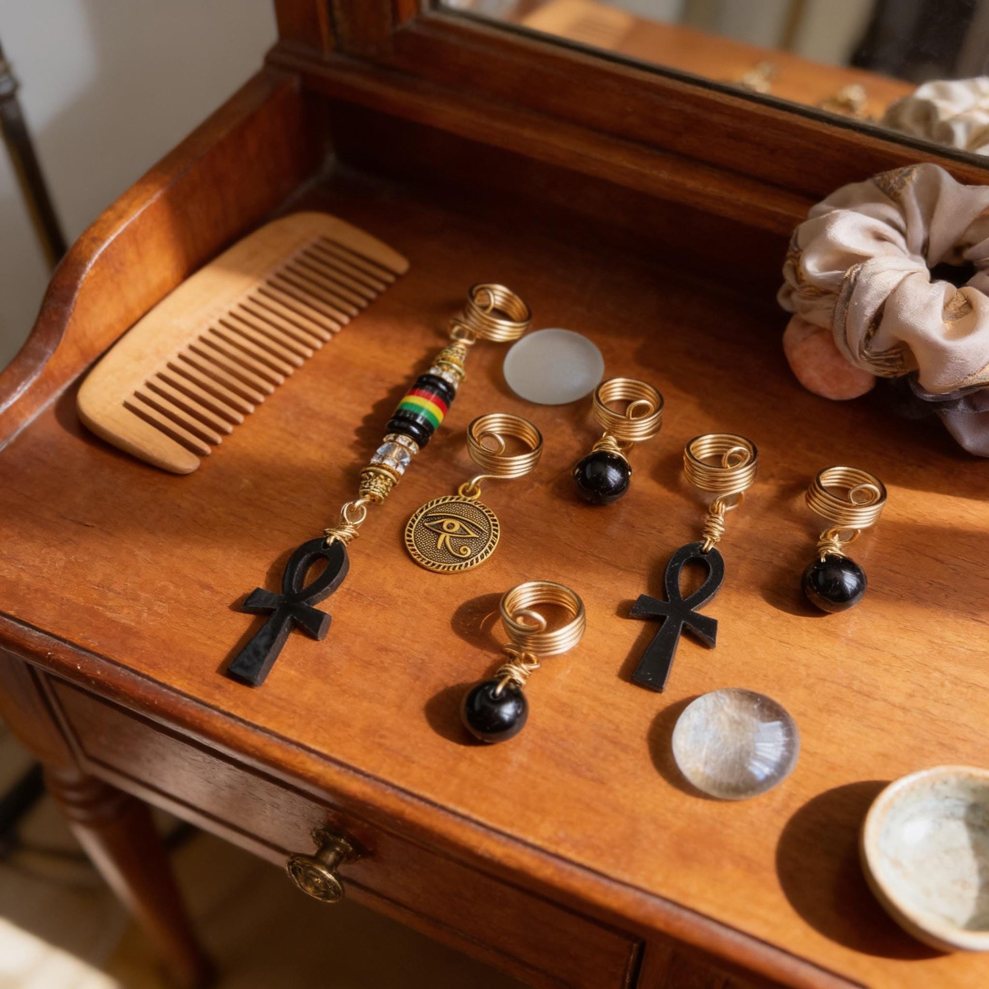 a collection of various jewelry and accessories, including a wooden comb, a necklace, and several rings, arranged on a wooden surface.
