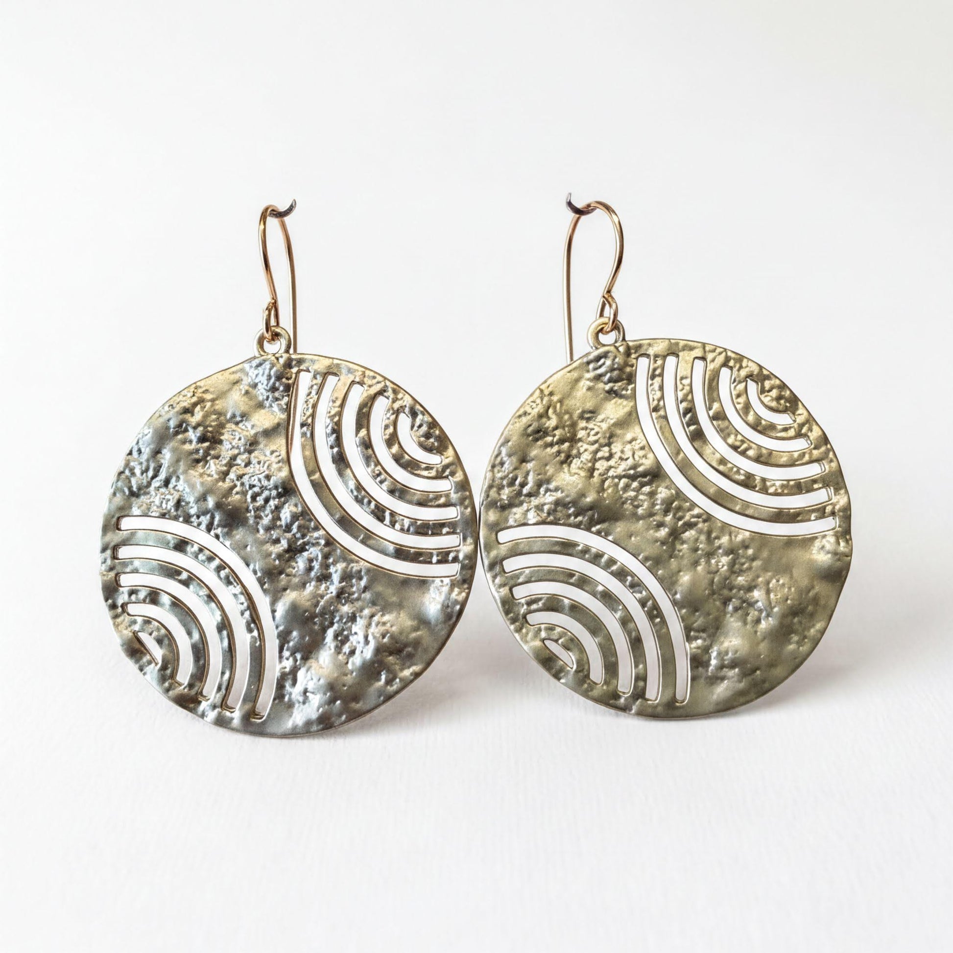 two round earrings with a metallic texture and a repeating wave pattern design.