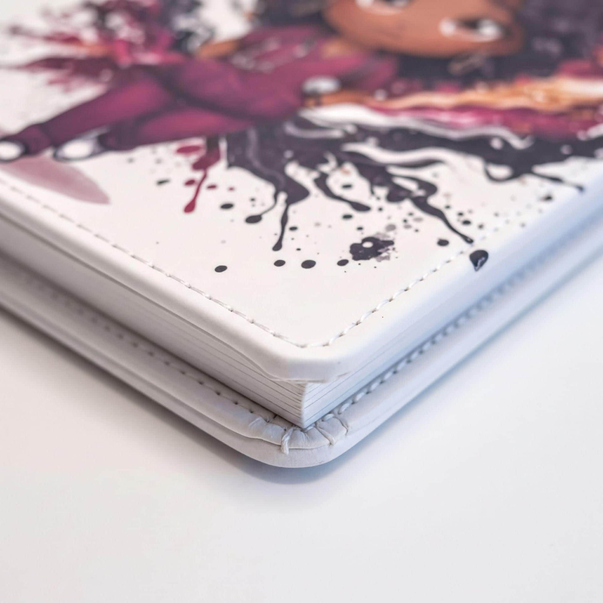 a close-up view of a white notebook or binder with a colorful, artistic design on the cover.