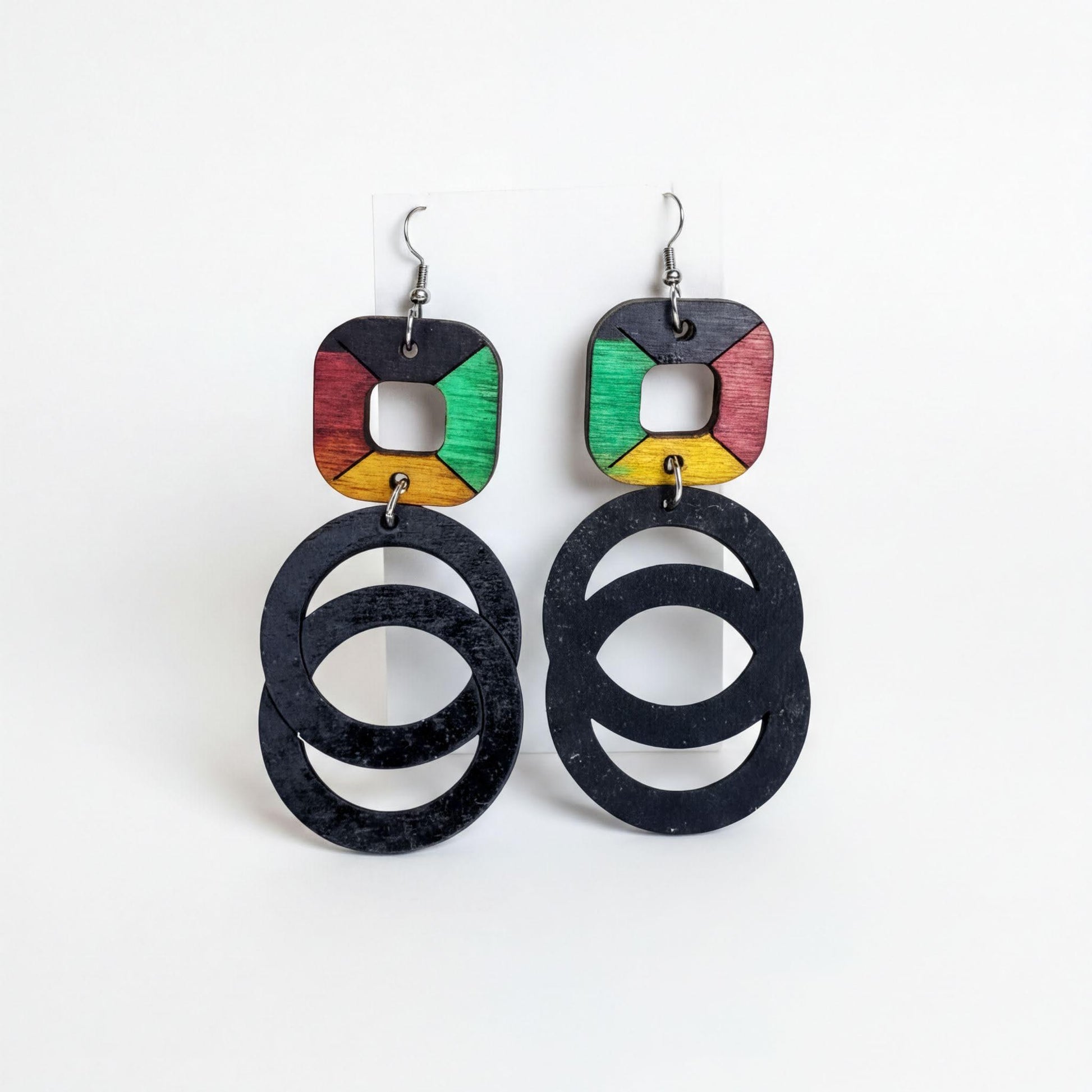 A pair of earrings with a unique design, featuring a combination of black, green, and yellow circular shapes.