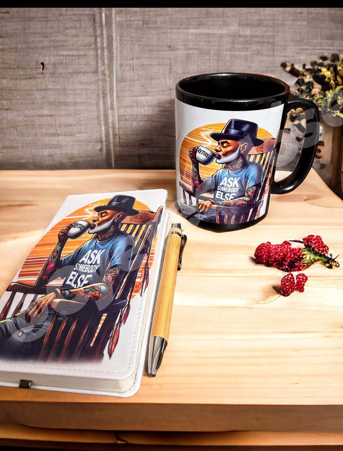a mug with a printed design of a man sitting in a chair and holding a cup, along with a notebook and a pen on a wooden surface.