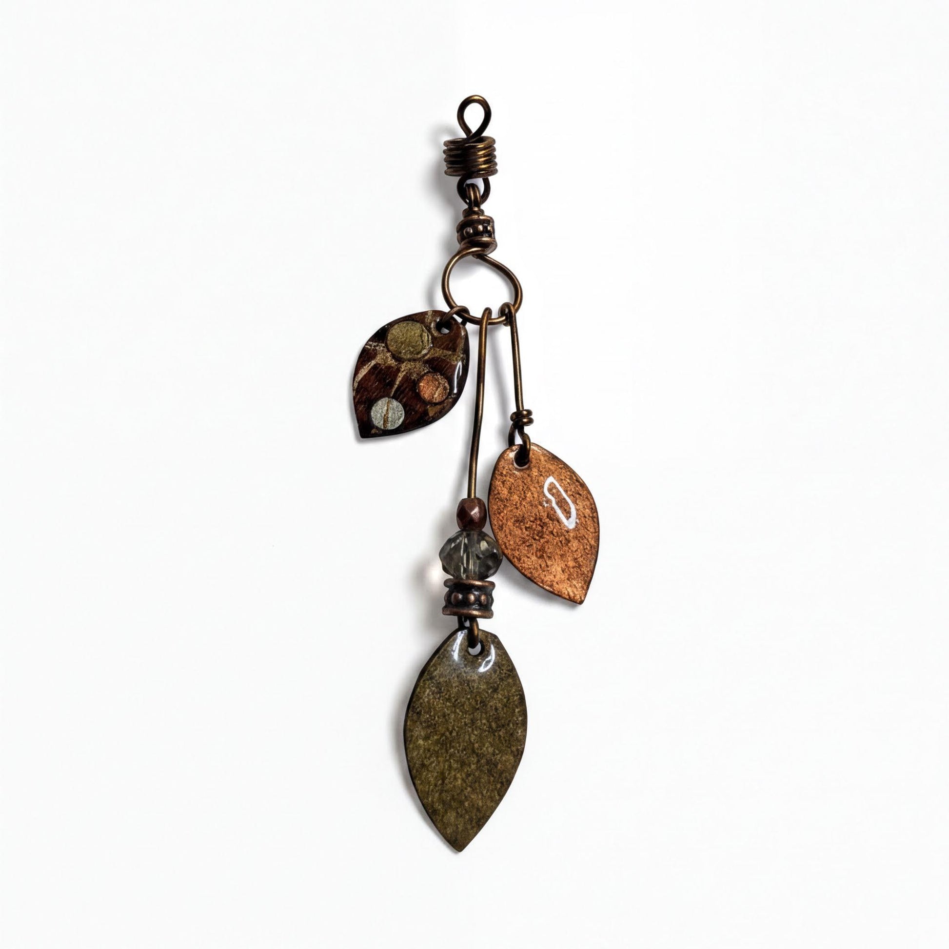 A decorative metal pendant with various leaf-shaped charms and a metallic hook at the top.