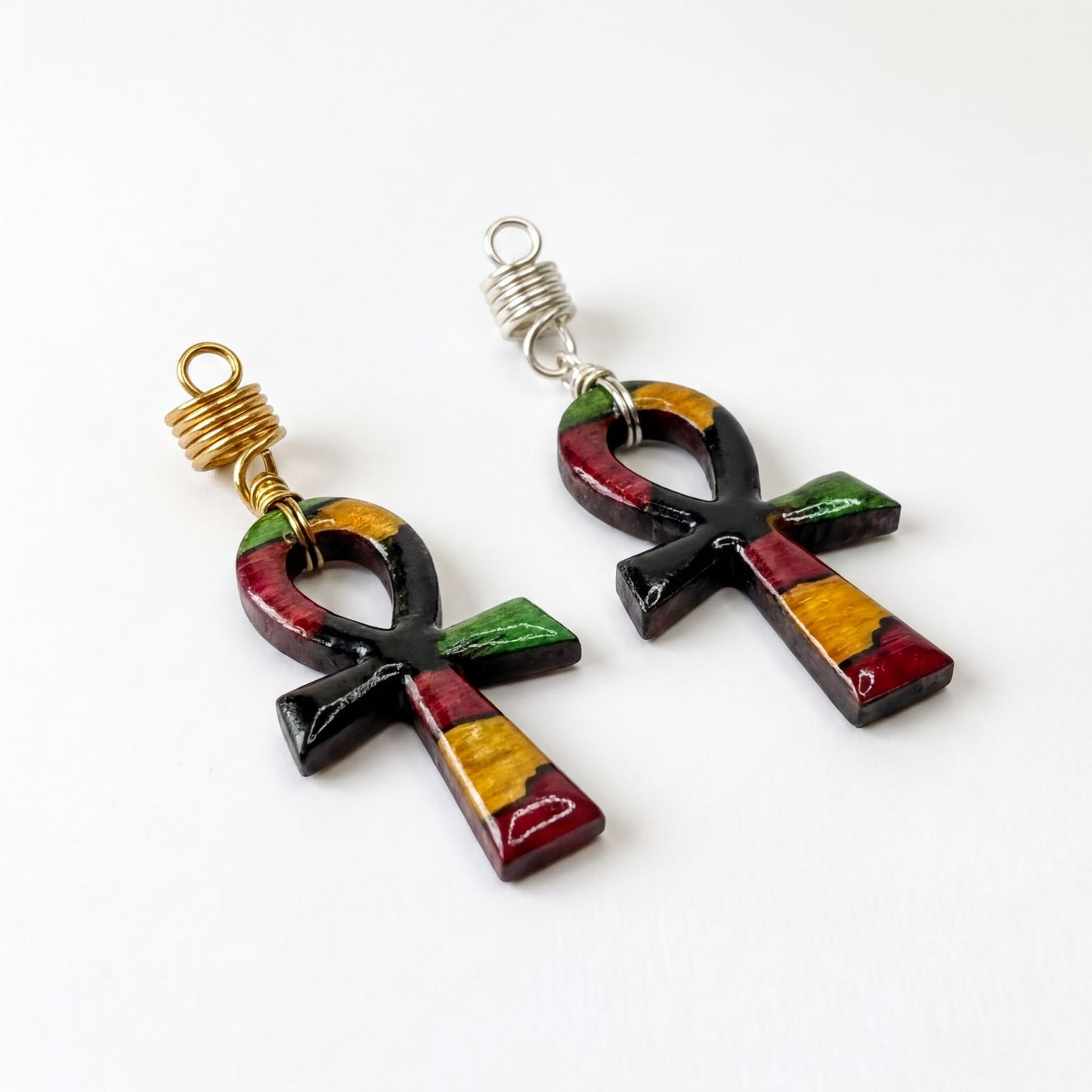 two colorful pendants, each with a cross-shaped design, hanging from a hook.