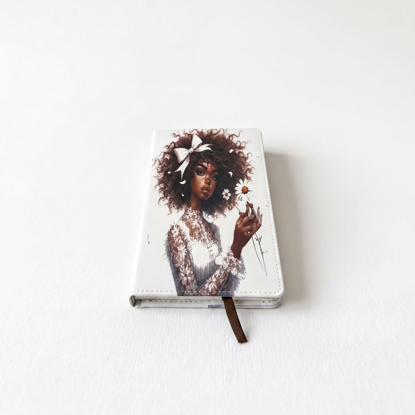 a notebook cover with a portrait of a woman with curly hair and a white dress.