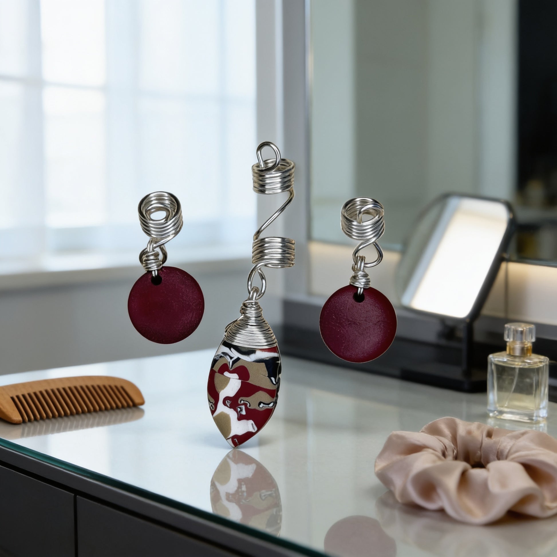 a collection of jewelry and beauty products on a vanity or dresser, including a pair of earrings, a necklace, a hair tie, a comb, and a perfume bottle.