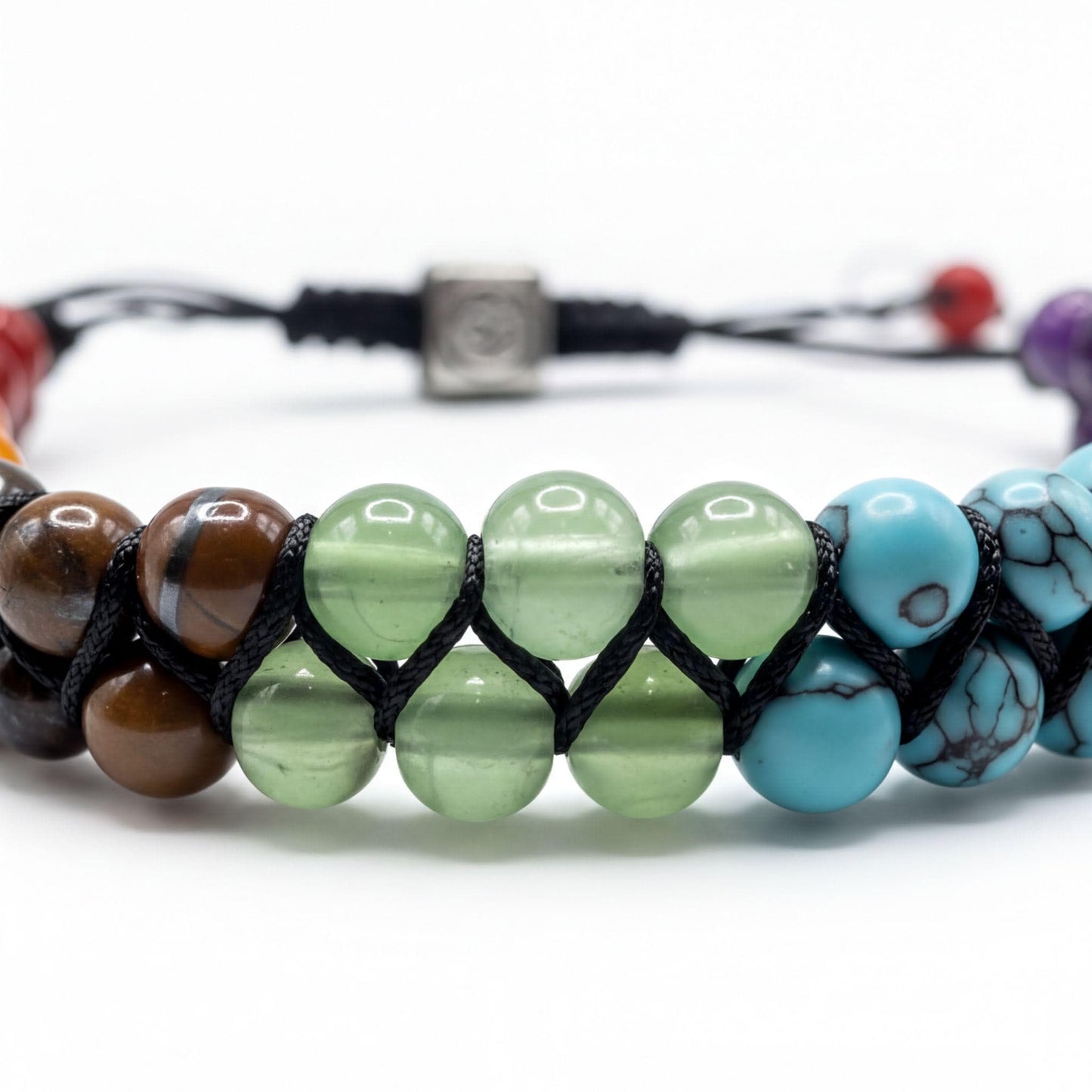 A colorful beaded bracelet with various colored beads, including green, blue, brown, and red, arranged in a row.