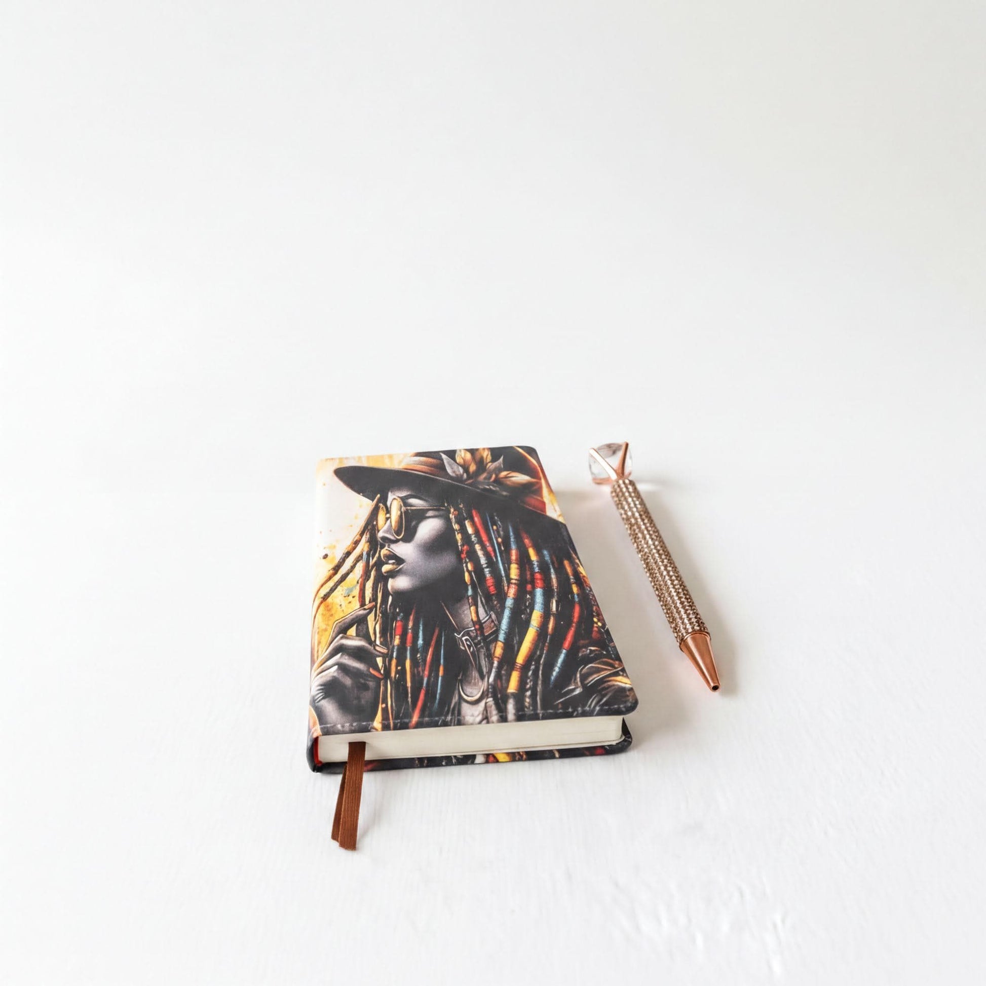 a notebook with a colorful, artistic design and a pen on a white surface.