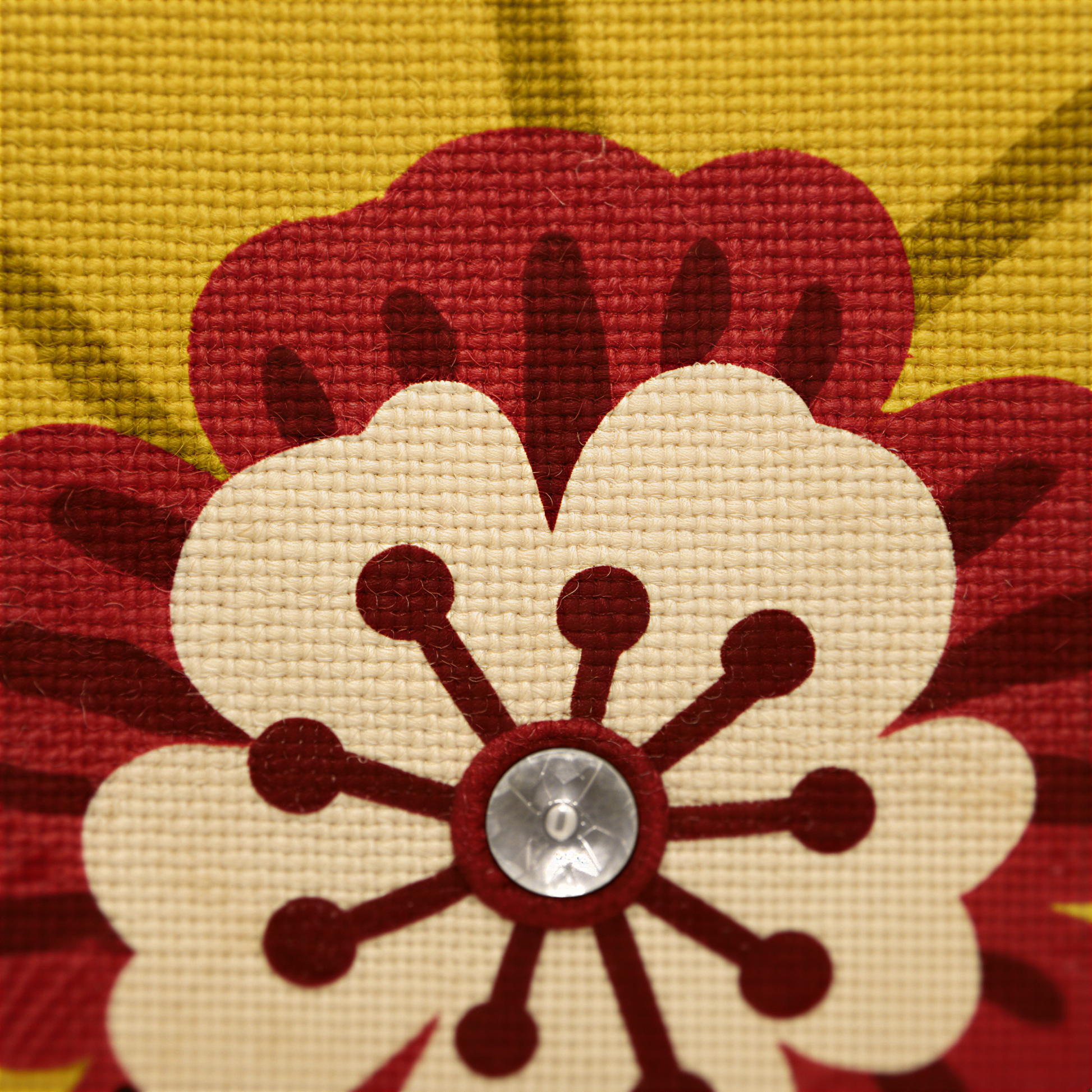 a close-up view of a colorful, textured fabric with a large, stylized flower design in the center.