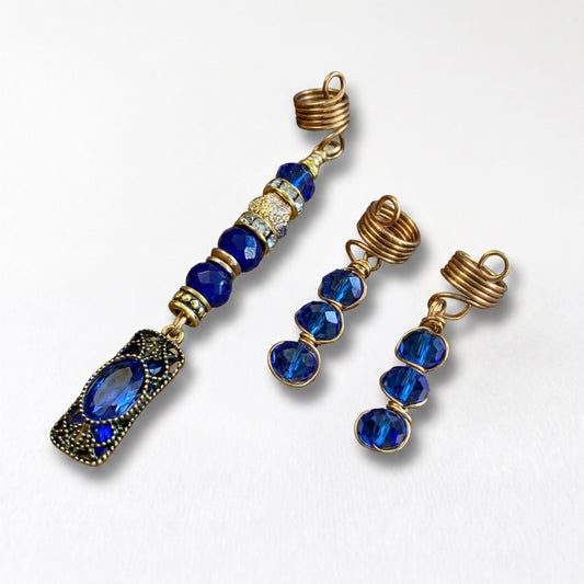 a set of three blue and gold jewelry pieces, including a necklace, earrings, and a hair clip, all adorned with blue gemstones.